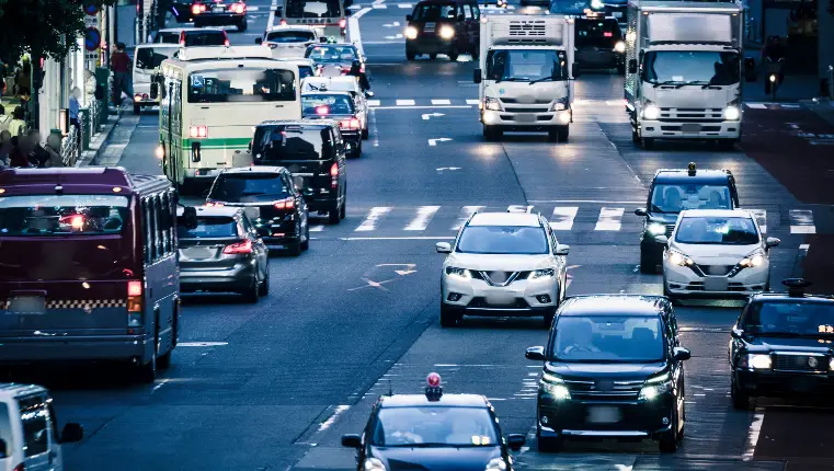 A busy city street filled with cars, buses, and trucks during rush hour, showcasing the vibrant energy of urban life.