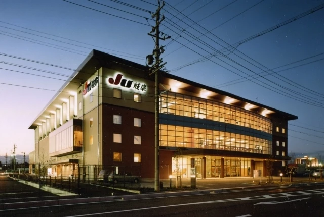 JU Gifu main auction building illuminated at dusk, a key location in the Japan Car Auction network.