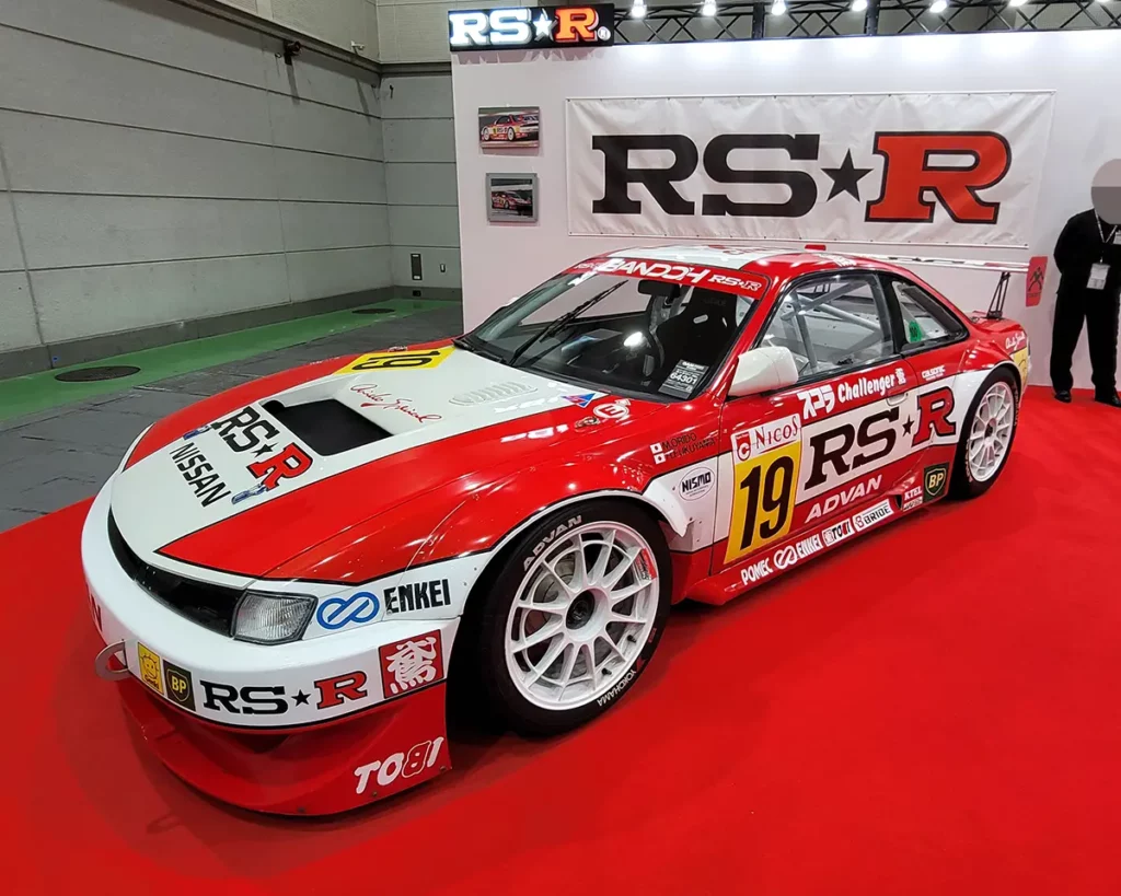 An RS★R-tuned S14 Silvia with a racing-style custom, featuring white and red sponsor decals.